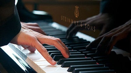 Fingers on a piano keyboard